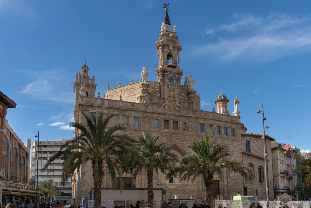 Valencia Cathedral in Ciutat Vella with palm trees and blue sky, Spain