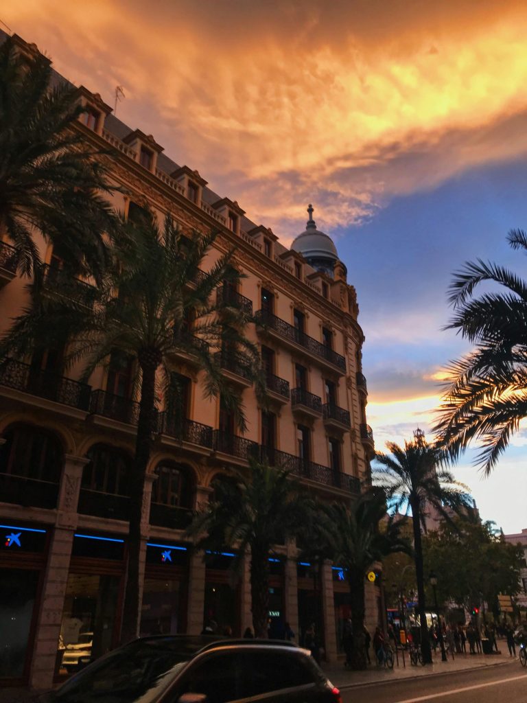 Historic building with palm trees at sunset in central Valencia, Spain