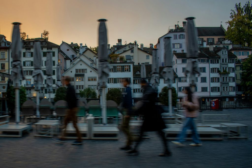 People walking near Zurich riverside buildings