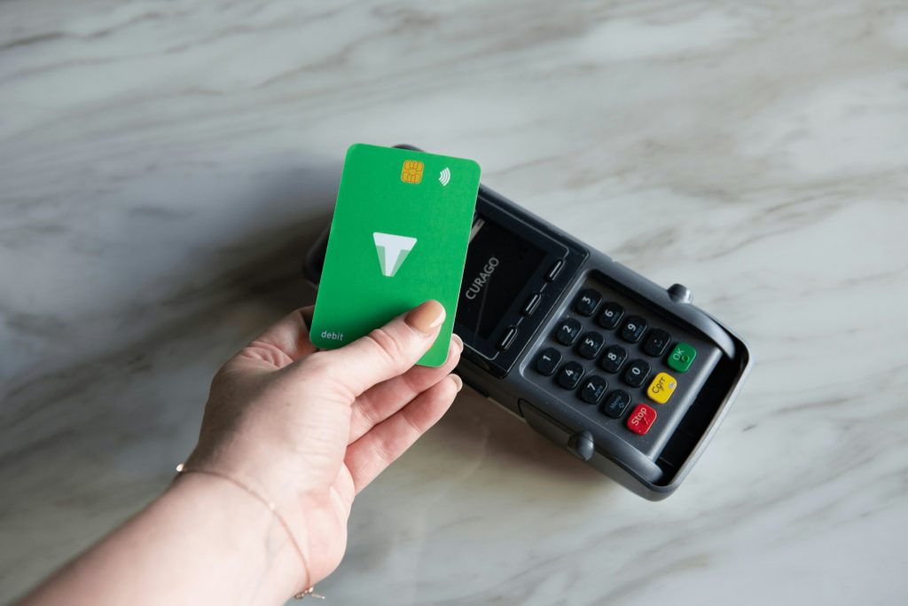 Hand holding debit card near payment termina