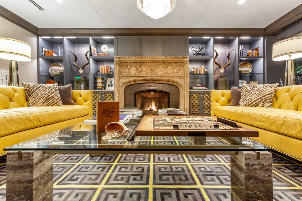 Cambria Houston Downtown lounge with fireplace and yellow sofas