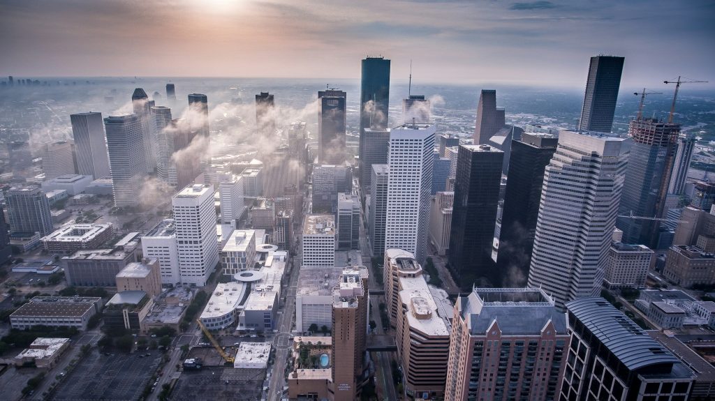 Aerial view of downtown Houston skyline with high-rise towers and morning haze