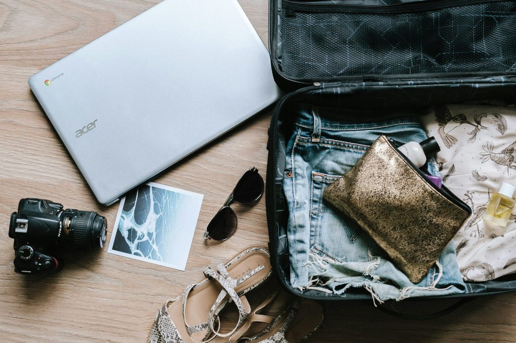 Open suitcase with clothes, camera, and travel items