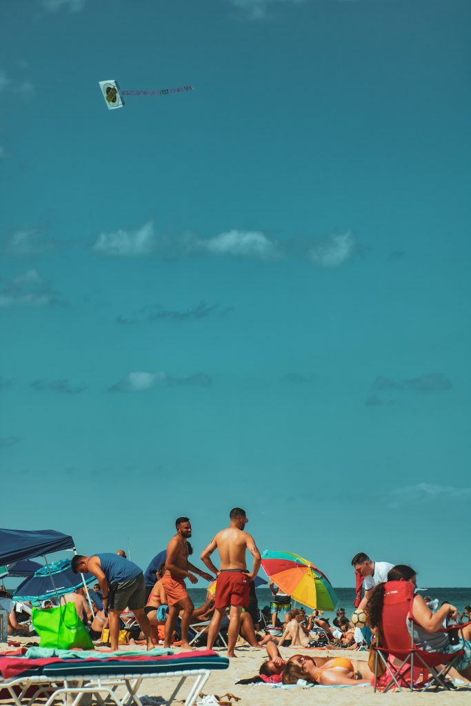 Crowded Miami beach with umbrellas and swimmers